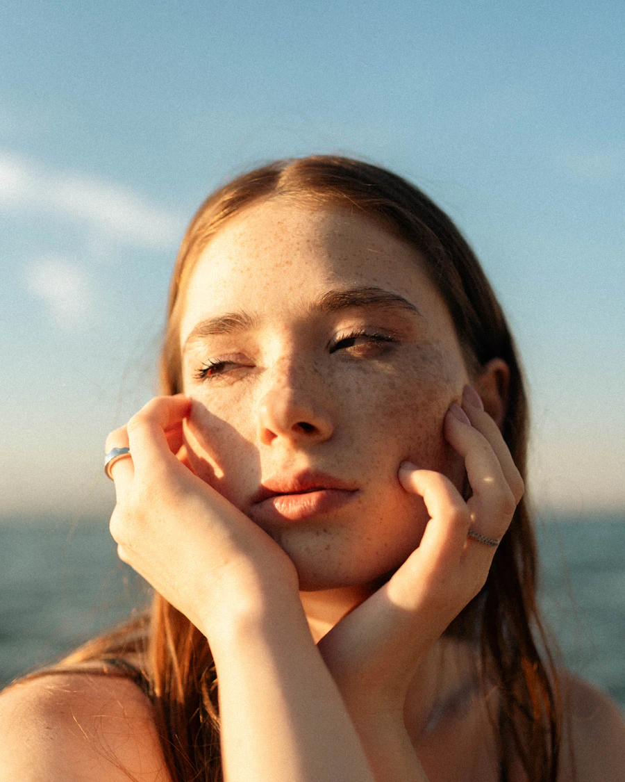 Woman resting her face in her hands by the sea
